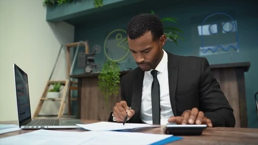 A professional reviewing plans and making notes at a desk